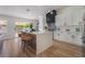 Modern kitchen boasts white cabinets, stainless appliances, island with seating, and sliding doors to the backyard at 9705 Standard Ave, Las Vegas, NV 89129