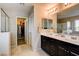 Modern bathroom featuring double sinks, a large mirror and separate shower and walk-in closet at 9846 Sunriver Meadows Ave, Las Vegas, NV 89148