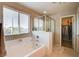 Well-lit bathroom with a deep soaking tub, separate shower, and convenient access to a walk-in closet at 9846 Sunriver Meadows Ave, Las Vegas, NV 89148