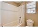 Bathroom shower/tub with white tiled walls and toilet with white blinds on window at 9846 Sunriver Meadows Ave, Las Vegas, NV 89148