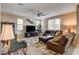 Comfortable living room with a leather sofa, ceiling fan, and patterned rug at 9846 Sunriver Meadows Ave, Las Vegas, NV 89148