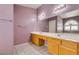 Light bathroom with long vanity with double sinks, tile floor and bright light at 1017 Guided Dancer Ave, Henderson, NV 89015