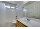 A well-lit bathroom features a shower-tub combination, white tiles, and a wooden vanity at 1017 Guided Dancer Ave, Henderson, NV 89015