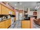 A well-lit kitchen boasts a spacious island, oak cabinets, granite counters, and an open layout at 1017 Guided Dancer Ave, Henderson, NV 89015