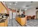 An open kitchen with oak cabinets, granite countertops, and modern appliances flows into a comfortable living area at 1017 Guided Dancer Ave, Henderson, NV 89015