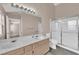 Modern bathroom features dual sinks, a stand-up shower with glass doors, an oversized mirror, and vanity lighting at 104 Hutton Ln, Las Vegas, NV 89145