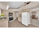 Traditional kitchen boasts appliances, neutral cabinets, countertops, tile floors, and access to the living area at 104 Hutton Ln, Las Vegas, NV 89145