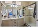 Bright bathroom featuring double sinks, modern fixtures, and a glass-enclosed shower at 10749 Turquoise Valley Dr, Las Vegas, NV 89144