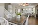 Open-concept dining area with a wood table, white chairs, and views to the living area and stairs at 10749 Turquoise Valley Dr, Las Vegas, NV 89144