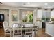 Dining area featuring a wooden table, white chairs, and sliding door access to the backyard and kitchen at 10749 Turquoise Valley Dr, Las Vegas, NV 89144