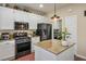 Well-lit kitchen features stainless steel appliances, granite countertops, pendant lighting, and ample cabinet space at 10749 Turquoise Valley Dr, Las Vegas, NV 89144