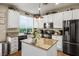 Bright kitchen boasts white cabinets, stainless steel appliances, granite countertops, and a charming center island at 10749 Turquoise Valley Dr, Las Vegas, NV 89144
