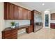 Modern kitchen features custom cabinets, built-in desk, stainless steel refrigerator, and pantry at 1134 Pandora Canyon St, Henderson, NV 89052