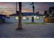 Exterior view of the back of a home with fresh green grass and palm trees in a dirt lot at 1209 S 17Th St, Las Vegas, NV 89104