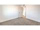 A cozy bedroom featuring neutral carpet, a white door, and a glimpse into an adjacent room at 1209 S 17Th St, Las Vegas, NV 89104