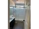 Bathroom featuring a shower with glass door, and vanity with dark cabinets and tile floor at 1921 Moonlight Bluff Ave, North Las Vegas, NV 89084