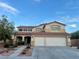 Two-story stucco home featuring a tile roof and a large three-car garage at 1921 Moonlight Bluff Ave, North Las Vegas, NV 89084