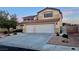 Two-story stucco home featuring a tile roof and a large three-car garage at 1921 Moonlight Bluff Ave, North Las Vegas, NV 89084