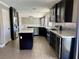 Bright kitchen featuring stainless appliances, tile flooring, granite counters, and dark cabinets at 1921 Moonlight Bluff Ave, North Las Vegas, NV 89084