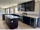 Spacious kitchen featuring stainless steel appliances, granite countertops, and dark wood cabinets at 1921 Moonlight Bluff Ave, North Las Vegas, NV 89084