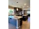 Bright kitchen featuring dark cabinets, tile flooring, stainless appliances, and granite countertops at 1921 Moonlight Bluff Ave, North Las Vegas, NV 89084