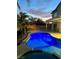 Backyard pool featuring dark tile coping, and a thatch-roofed tiki bar at 1921 Moonlight Bluff Ave, North Las Vegas, NV 89084