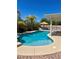 A swimming pool with a spa, surrounding landscaping and a palapa at 1921 Moonlight Bluff Ave, North Las Vegas, NV 89084