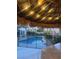 Inviting pool with tiki hut, string lights, and black safety fence at 1921 Moonlight Bluff Ave, North Las Vegas, NV 89084
