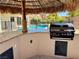 Poolside bar area with a granite countertop, sink, grill and built-in storage at 1921 Moonlight Bluff Ave, North Las Vegas, NV 89084