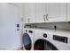 Modern laundry room with front-loading washer and dryer, and ample cabinet space at 1953 Moyer Dr, Henderson, NV 89074