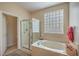 Bright bathroom featuring a soaking tub, glass block window, and separate shower at 2365 Wisconsin Dells Dr, Henderson, NV 89044
