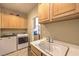 Functional laundry room equipped with a sink, washer, dryer, and storage cabinets at 2365 Wisconsin Dells Dr, Henderson, NV 89044