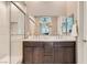 Modern bathroom featuring double sinks, dark wood cabinets, and a glass-enclosed shower at 2507 Silent View Ave, Henderson, NV 89044