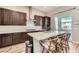 Spacious kitchen with dark wood cabinets, quartz countertops, and stainless steel appliances at 2507 Silent View Ave, Henderson, NV 89044
