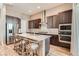 Eat-in kitchen island with dark cabinets, quartz countertops, stainless appliances, and barstool seating at 2507 Silent View Ave, Henderson, NV 89044