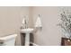 A clean powder room with modern fixtures, including a pedestal sink and toilet at 2507 Silent View Ave, Henderson, NV 89044