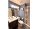 Modern bathroom featuring a glass enclosed shower, dark wood vanity, and blue accent wall at 2549 Sundew Ave, Henderson, NV 89052