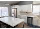 Well-lit kitchen featuring white cabinets, a marble backsplash, and an island with seating at 2549 Sundew Ave, Henderson, NV 89052