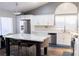 Bright kitchen featuring white cabinets, stainless appliances, marble counters, island, and a vaulted ceiling at 2549 Sundew Ave, Henderson, NV 89052