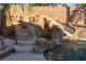 Backyard oasis with a rock waterfall, slide, and lush tropical landscaping surrounding the pool at 2549 Sundew Ave, Henderson, NV 89052
