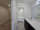 Bathroom featuring a dark vanity and a bathtub with white tile surround at 3056 Garnet Ct, Las Vegas, NV 89121
