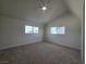 Spacious bedroom with vaulted ceilings, neutral carpet, and bright natural light from two windows at 3056 Garnet Ct, Las Vegas, NV 89121