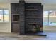 A large stone fireplace with a pool visible through the windows at 3056 Garnet Ct, Las Vegas, NV 89121