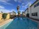 The backyard features a private pool, surrounded by lush landscaping and mature palm trees at 3056 Garnet Ct, Las Vegas, NV 89121