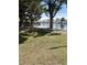 Scenic waterfront view featuring trees, grass, a bench, and a glimpse of houses in the distance at 3150 Soft Breezes Dr # 1033, Las Vegas, NV 89128
