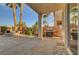 A covered patio with a built-in grill, seating area, and view of palm trees under clear skies at 3632 Red Fir St, Las Vegas, NV 89135