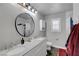 Modern bathroom features a dual sink vanity, large round mirror, and tiled shower-tub combination at 3632 Red Fir St, Las Vegas, NV 89135