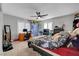 Neutral carpeted bedroom featuring a ceiling fan, natural light, and a desk area at 3632 Red Fir St, Las Vegas, NV 89135