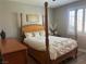 Bright bedroom featuring a wooden four poster bed, dresser and window with plantation shutters at 3632 Red Fir St, Las Vegas, NV 89135