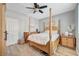 Bedroom features a four-poster bed, ceiling fan, light gray walls and wood-look floors at 3632 Red Fir St, Las Vegas, NV 89135